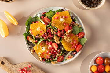 Wall Mural - Vegan salad with citrus fruits, lettuce leaves and pomegranate. Christmas salad. 