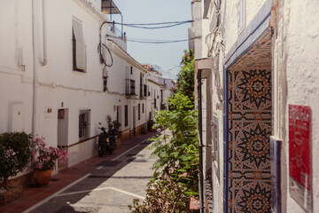 Old town of Nerja in Spain. Mosaic entrance in the house. Beautiful traditional architecture of the Spanish town in the rays of the setting sun