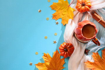 Wall Mural - Autumn composition. Scarf, cup of coffee, pumpkins, cinnamon sticks, maple leaves and confetti on blue background. Flat lay, top view, copy space.