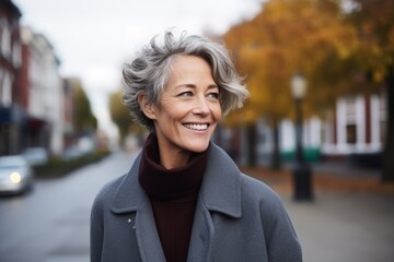 Poster - Portrait of a happy senior woman in a grey coat on the street