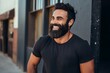 © Loli - Portrait of a handsome young bearded man in a black t-shirt smiling and looking at the camera