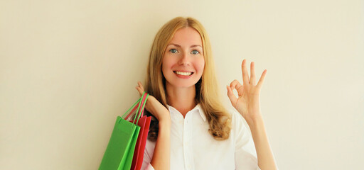 Wall Mural - Portrait of beautiful happy smiling middle aged woman posing with shopping bags in eyeglasses