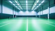 © aubriella - A vibrant indoor badminton court with green flooring, white boundary lines, and overhead lighting