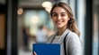 © Berkah - Young smiling businesswoman with blue folder.