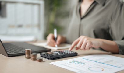 financial, economic, accounting, finance, investment, analysis, savings, audit, planning, calculate. A woman is sitting with a calculator and a stack of coins.