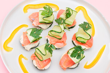 Wall Mural - Canapes without Bread with Fresh Salmon, Cucumber and Cream Cheese on White Plate. Easy Breakfast. Diet Food. Quick and Healthy Sandwiches. Healthy Snacks with Tasty Fillings