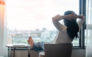 Wall Mural - Simple lifestyle take it easy relaxation of Asian businesswoman, healthy woman resting in comfort business hotel or city home living room having lazy free time with peace of mind and work-life balance