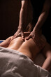 © Yevhenii - A relaxing back massage performed by a woman's hands, emphasizing comfort and wellness. Ideal for themes of spa treatments, body care, and therapeutic massage in the dark
