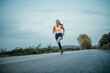 © La Famiglia - Shot of a young beautiful woman training for a marathon outdoors