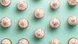 © Intelligent Horizons - Overhead view of delectable cupcakes with soft pastel colored frosting and vibrant sprinkles arranged on a light green background  This clean
