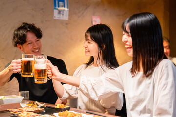 Wall Mural - 居酒屋でお酒を飲む若い男女