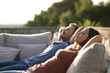 © PheelingsMedia - Relaxed couple sitting in an exterior sofa in a terrace