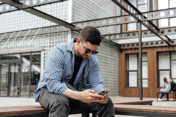 Young man sitting on a bench in a park