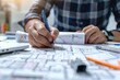 © Isuru - architect working and sketching architectural drawing plan on table in office