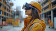 © Izzain - A young woman wearing a hard hat and safety vest uses a virtual reality headset while standing on a construction site.