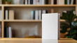 © Gita - blank white book mockup stands on wooden table, with blurred bookshelf and plant in background. Perfect for books mockups, education, or publishing themes mockup