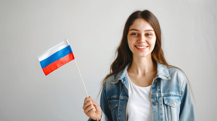 A pretty sweet white woman waves a small Russian flag on a stick. A happy exchange student. Learning the Russian language. Immigration and tourism. Patriotism and pride