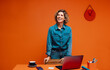 © Jacob Lund - Confident female manager using laptop in a bold orange contemporary office space