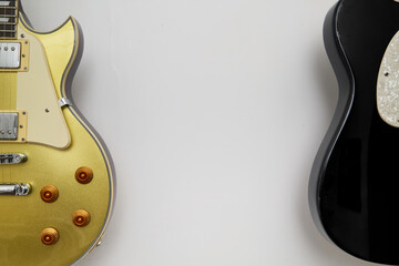 A Pair of black and gold vintage electric guitars, hung on the wall