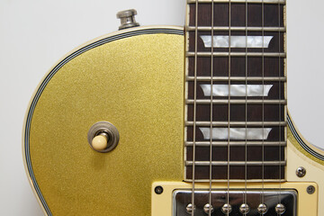 Close-up photograph of a vintage gold-plated electric guitar, details