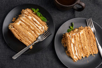 Wall Mural - Multi layered honey cake known as Medovik on a black plate, table top view. Homemade cake