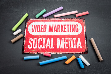 Wall Mural - video marketing and social media. sign with text and colored pieces of chalk on a dark chalkboard ba