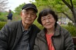 © Oleksandr - Senior Asian Couple Sitting in Park Together. Enjoying Active Retirement in the Countryside