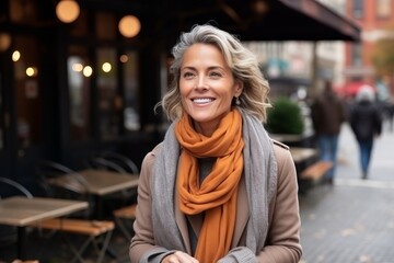 Wall Mural - Portrait of a beautiful middle aged woman smiling at the camera outdoors