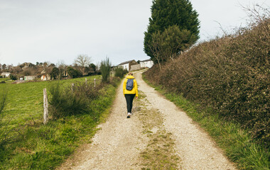 Young girl doing trekking Camino Santiago path during fall season - Travel and autumn lifestyle concept - Main focus on body