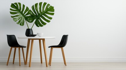 Modern dining setup featuring two black chairs, a round table, and vibrant green leaves in a minimalist setting.