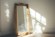 © Mathias - A mirror with a golden colored frame standing up against a white wall