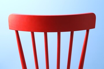 Poster - Red wooden chair on light blue background, closeup