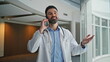 © stockbusters - Smiling doctor talking smartphone in hospital closeup. Healthcare worker discuss