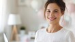 © DuangphonKPR - A smiling woman in a cozy, softly lit room surrounded by pastel decorations, exuding warmth and positivity.