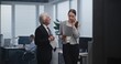 © Framestock - Work in modern office of bank or stock exchange company: Female financial specialist talks to business partner on mobile phone, analyzes papers and documents with senior boss. Businesspeople concept.