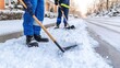 © lililia - Two workers clear snow with shovels from a construction site, ensuring safe access in winter conditions