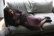 © Caia Image - Disabled woman lying with tablet on sofa