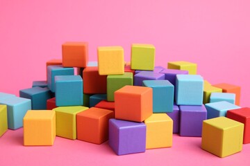 Wall Mural - Many wooden colorful cubes on pink background