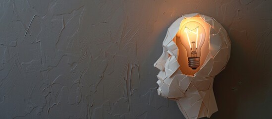 Wall Mural - Business idea illustrated by a paper human head with a light bulb on a grey background with copy space image