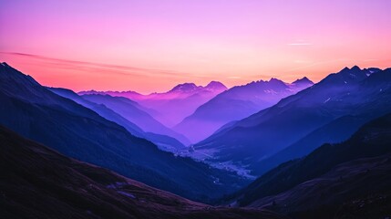 A beautiful view of the mountains at dusk, with the last rays of sunlight lighting up the peaks and the sky slowly turning purple and orange.