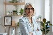 © Svetlana - Stylish middle-aged European businesswoman confidently posing at her modern office workspace, embodying leadership and professionalism