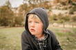 © Austockphoto - Portrait of little blond boy wearing woollen hoodie in winter with relaxed expression