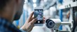 © COK House - In a manufacturing plant, a man in a black shirt uses a smartphone to photograph a modern white surveillance camera with advanced features, emphasizing technology and security.