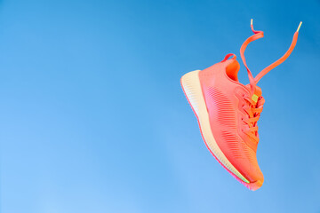 Wall Mural - Stylish sneaker in air against light blue background, space for text