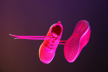 Poster - Pair of stylish sneakers in air against dark purple background