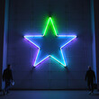 © Cozy Coffee Bar - Two men walking towards glowing neon star on wall