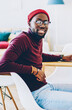 © BullRun - Portrait of african american hipster guy enjoy new software for netbook with mock up screen working on freelance at home, cheerful man looking at camera satisfied with earning money on laptop at flat