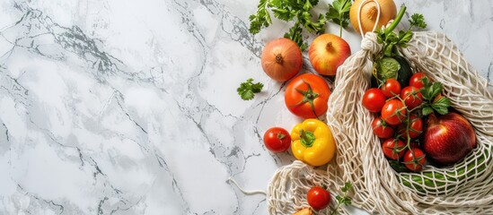 Wall Mural - Fresh produce arranged in a net bag on a white marble backdrop in a flat lay setting ideal for a copy space image