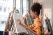© wichayada - Young Girl Drawing on Canvas in a Bright Painting Studio with Natural Light and Artistic Ambiance