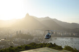 view from the sugar loaf over Rio de Janeiro in Brazil during sunset with a tourism helicopter taking off